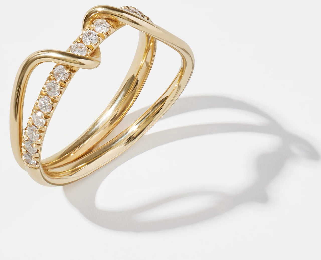 Sculptural gold ring with a row of diamonds