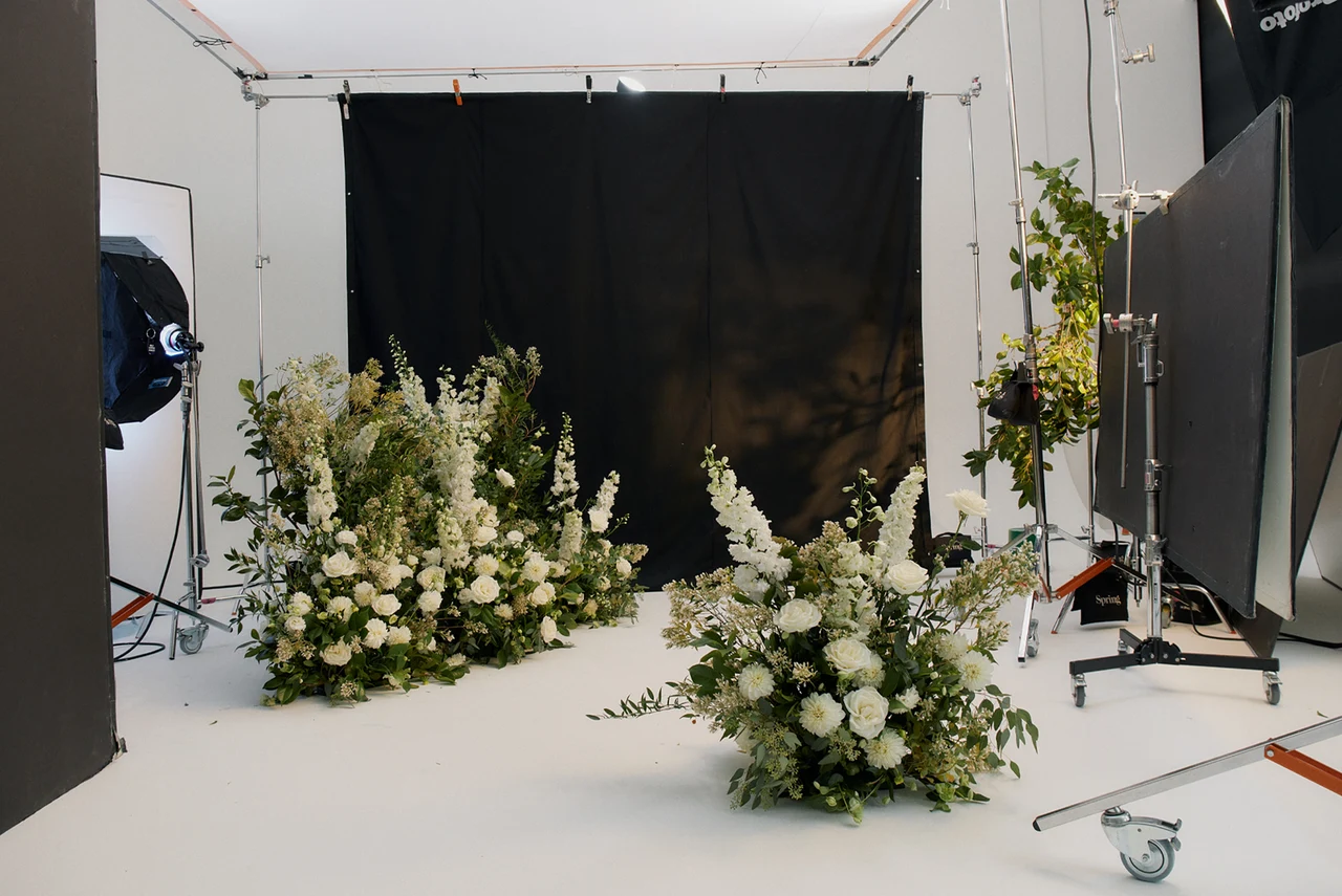 Before retouching: floral studio set with equipment and backdrop edges