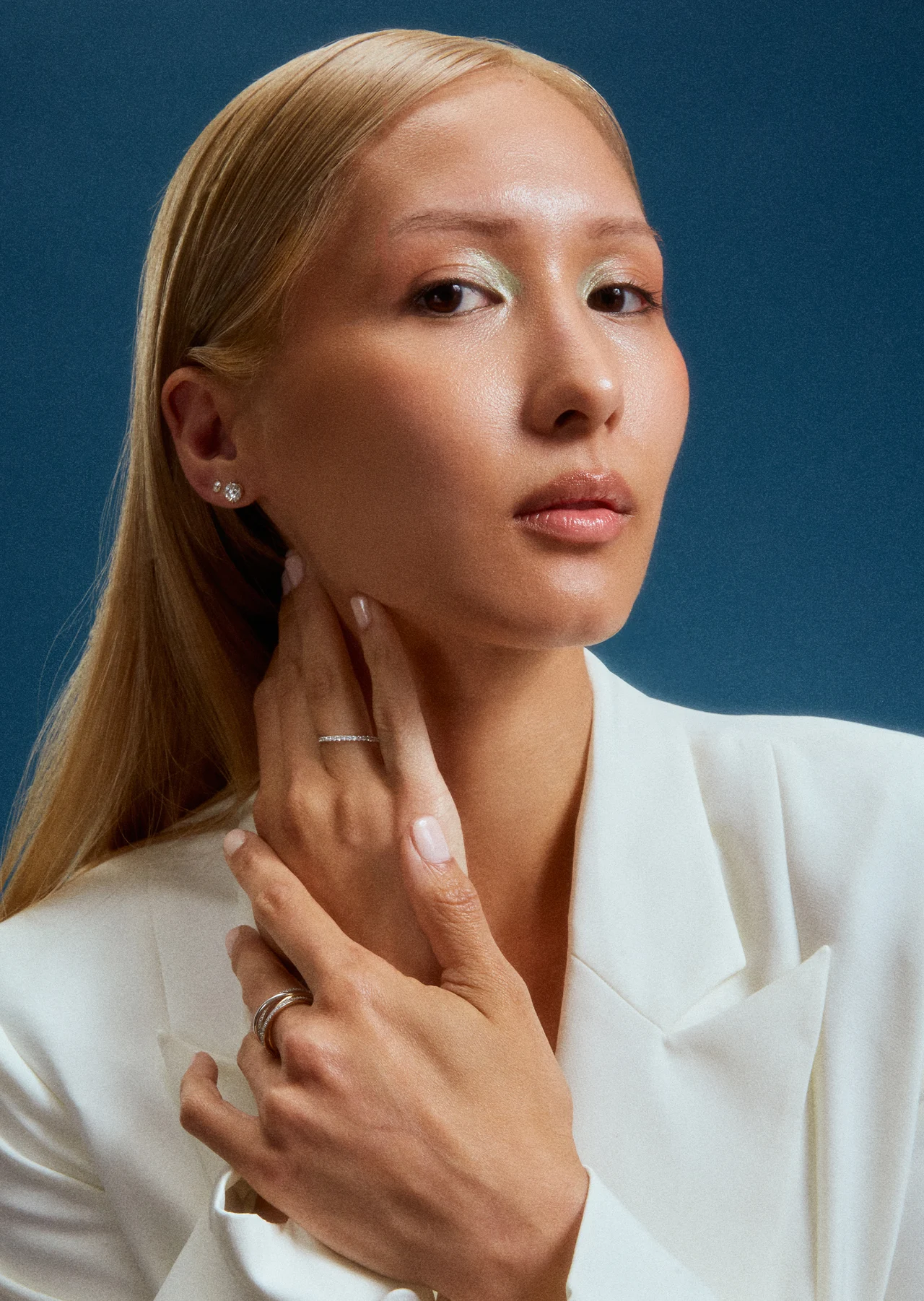 Portrait with delicate gold jewelry against a blue background