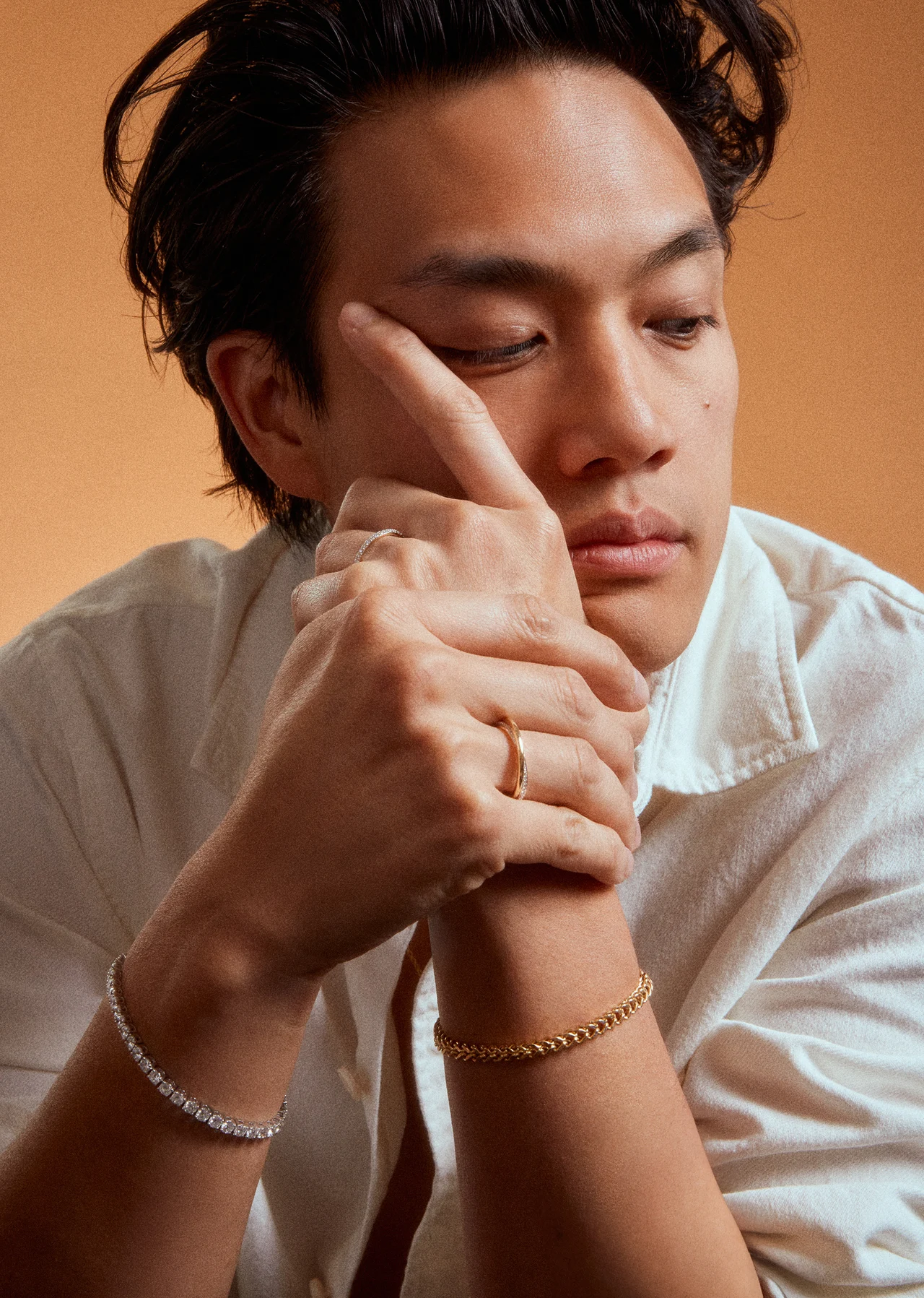 Male model wearing a gold bracelet and ring