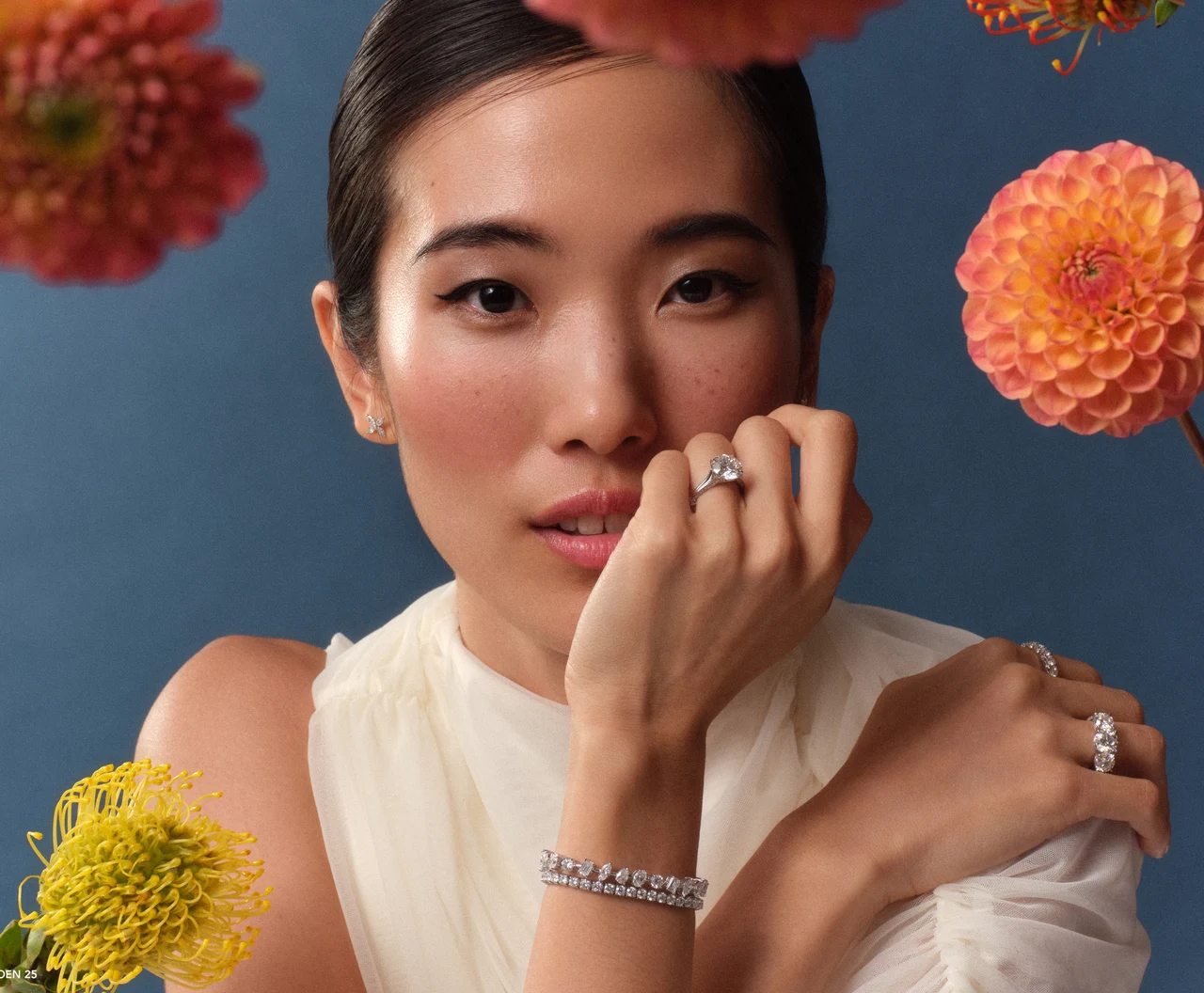 Jewelry portrait surrounded by colorful flowers against a blue background