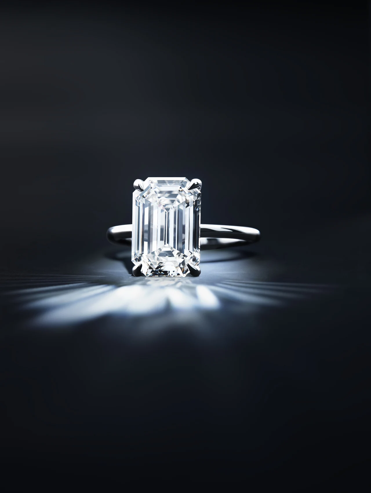 Emerald-cut diamond ring against a dark background